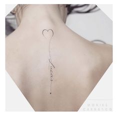 the back of a woman's neck with a heart shaped balloon attached to it