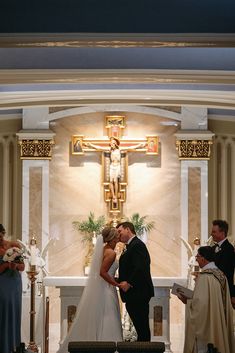 a bride and groom are kissing in front of the alter at their church wedding ceremony