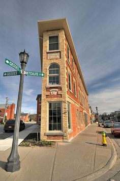 a street sign in front of a tall brick building on the corner of an intersection