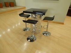 three stools and a table in the middle of a room with hard wood flooring