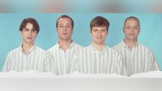 three men are standing in front of a blue background and one man is looking at the camera