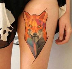 a close up of a person's thigh with a tattoo on it and an orange fox