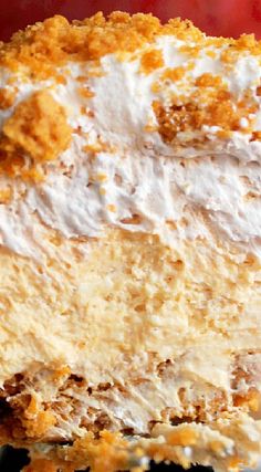 a piece of cake with white frosting and orange crumbs on the top