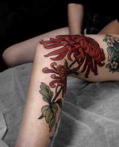 a woman laying on top of a bed covered in tattoos