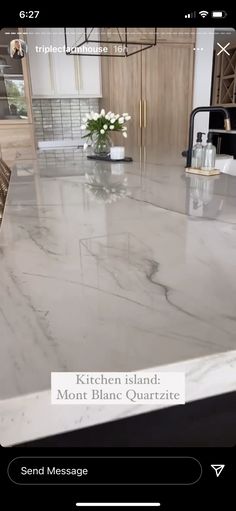 a marble counter top in a kitchen with white flowers on the counter and an advertise