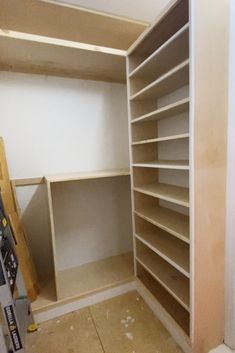 an empty closet with shelves and tools on the floor