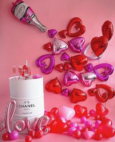 pink and red heart shaped balloons next to a canister with the word love on it