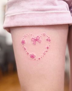 a woman's thigh with pink tattoos and bows on her thighs, in the shape of a heart