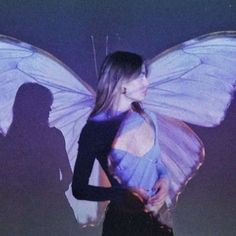 a woman standing next to a giant butterfly