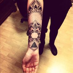 a person's arm with a tattoo on it that has geometric shapes and triangles