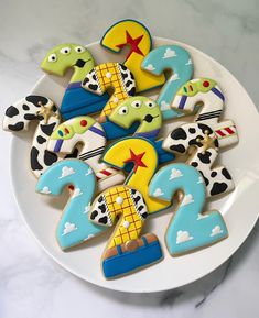 decorated cookies are arranged on a white plate