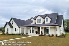 a large white house with black roof and windows