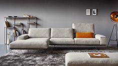 a modern living room with grey walls and carpeted flooring, including a gray sectional sofa