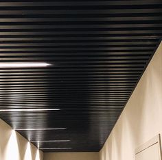 an empty hallway with white walls and black ceiling