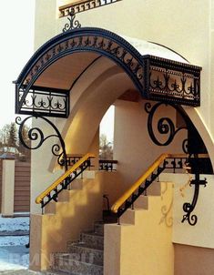 an arched entrance to a building with stairs and railings on either side, in the snow