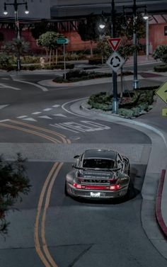 a car is driving down the street at night