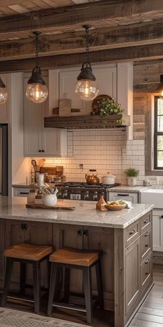 a kitchen with two stools in front of the island and three lights above it