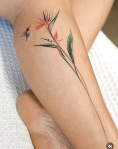 a tattoo on the leg of a woman with flowers and leaves painted on her legs