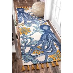 an octopus rug with tassels on the floor in front of a door and window