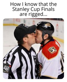 two hockey players are kissing each other on the sidelines, and one is wearing a referee's uniform