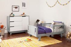 a child's bedroom with white walls and wooden floors, including a gray crib