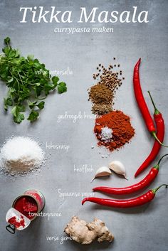 the ingredients to make tikka masala are displayed on a gray surface, including red peppers, garlic, parsley, and seasoning