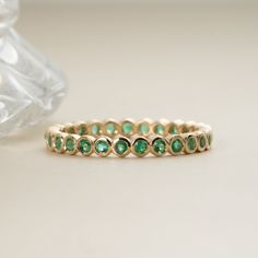 Nyra Timeless, elegant & dainty, this rich shade of green will make you feel like royalty each time you gaze at your hand! This can be your vibrant and unique wedding band, yet also the perfect dainty ring to add a pop of color to your solid gold ring stack. This is a full eternity band surrounding the entire finger. Choose your metal and size, and we will make it custom for you. May’s birthstone, this is a stunning ring to stack with your wife’s wedding ring! - Handmade- Solid Gold- Natural Eme Emerald Wedding Band Stack, Wedding Band With Emeralds, Green Emerald Wedding Band, Emerald Stone Wedding Band, Emerald Stacking Ring, Colorful Wedding Band, Emerald Green Wedding Band, Green And Gold Ring, Green Wedding Band