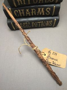 two harry potter books and a wand on a table with some tags attached to it