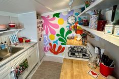 a kitchen with colorful wallpaper and wooden counter top next to white stovetop oven