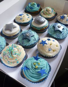 twelve cupcakes with blue frosting and stars on them