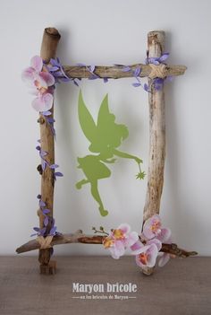 a wooden frame decorated with flowers and a tinkerbell