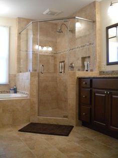 a bathroom with a walk in shower next to a bath tub