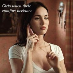 a woman holding a cell phone to her ear and looking at the camera with a caption that reads, girls when their comfort necklace