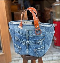 an old pair of jeans has been transformed into a purse with studded handles and straps