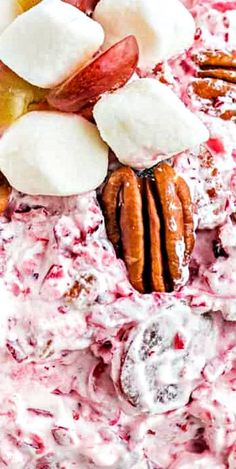 a bowl filled with fruit and nuts on top of a white table topped with whipped cream