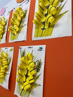 four pieces of paper cut to look like yellow flowers on a red wall with writing