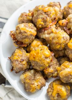 a white plate topped with meatballs covered in cheese