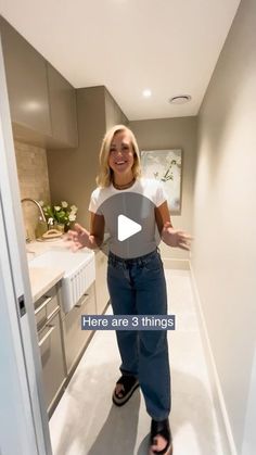 a woman is standing in the hallway with her hands out and smiling at the camera