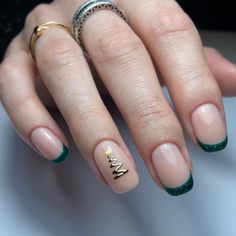 Nude nails are given a festive twist with deep green French tips that subtly evoke the holiday spirit. The ring finger features a delicate golden Christmas tree with a shining star at its peak, adding a sophisticated focal point to the minimalist design. This look combines the elegance of a classic French manicure with understated holiday charm, perfect for those who prefer a refined take on Christmas nail art. Christmas Tree Nail Designs, Christmas Tree Nail Art, Nail Art Noel, Tree Nail Art, Christmas Tree Nails, Tree Nails, Subtle Nails