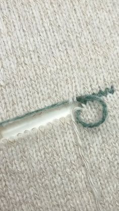 a needle is hooked up to the side of a piece of fabric