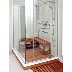 a walk in shower sitting next to a wooden bench