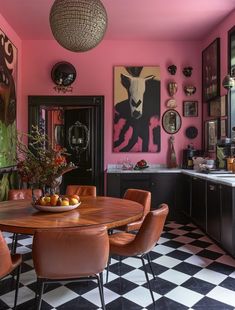 a dining room with black and white checkered flooring, pink walls and pictures on the wall