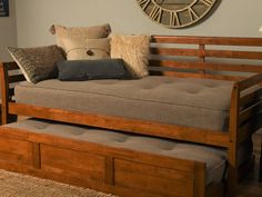 a day bed with pull out trundle and storage underneath it in a living room