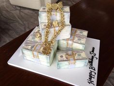 a birthday cake made to look like stacks of money with chains and gold coins on top