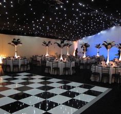 a banquet room with black and white checkered flooring, palm trees on the wall