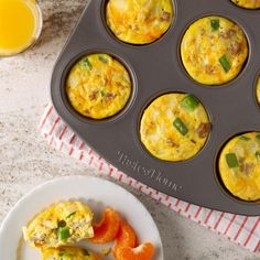 an egg muffin is sitting on a plate next to some oranges and a cupcake tin