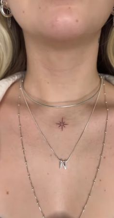 a close up of a woman wearing two necklaces and one has a star on it