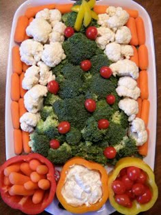 a christmas tree made out of cauliflower and carrots in a tray on a table