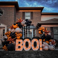 a large halloween boo sign in front of a house with balloons and decorations on it