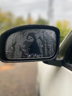 the rear view mirror on a car with a skull and crossbones sticker